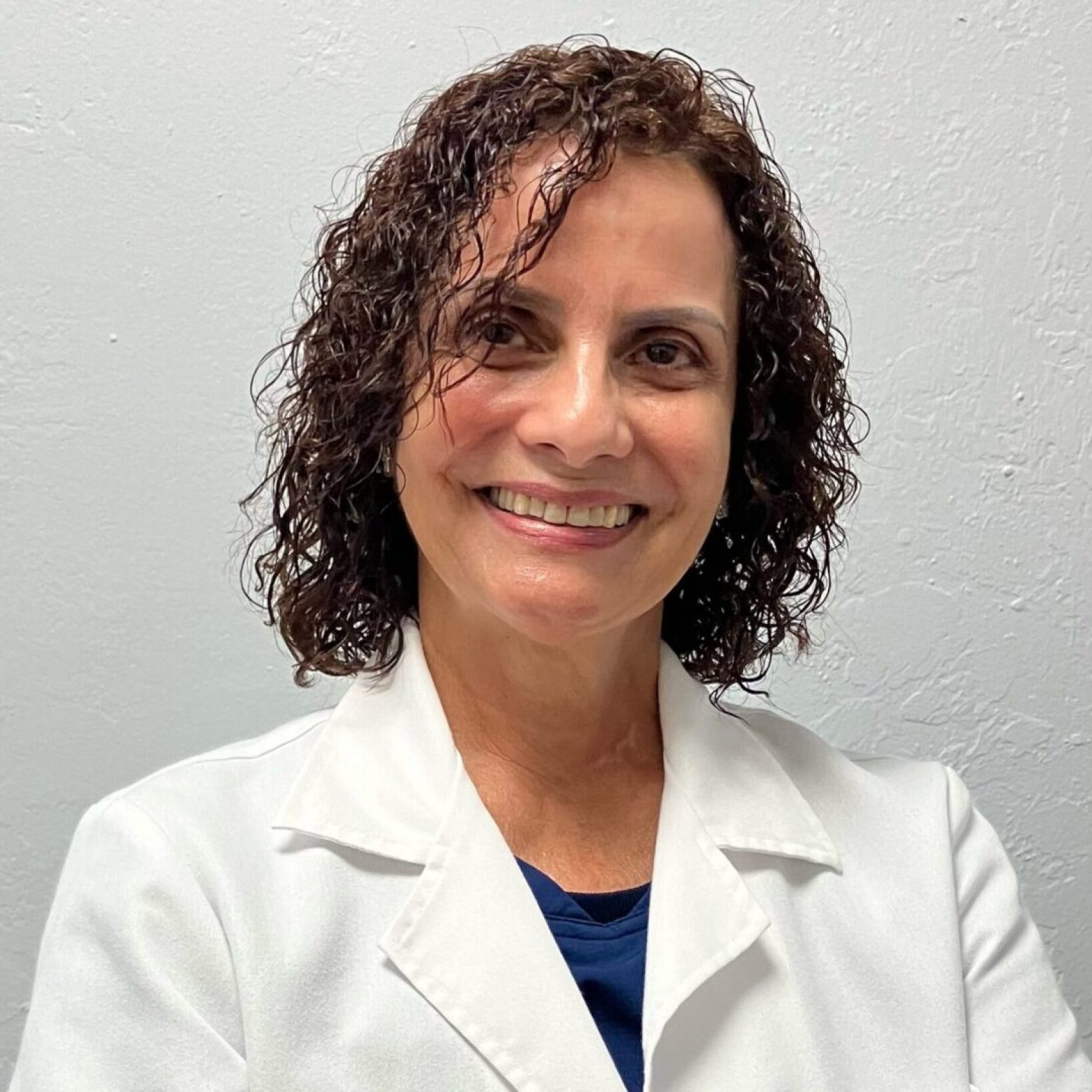 Smiling woman wearing white lab coat